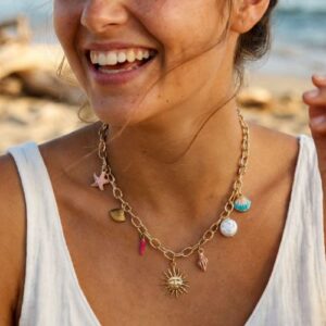 jeune femme à la plage qui porte le collier breloque de la mer