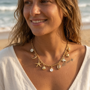 jeune femme à la plage qui porte un collier charms très tendance